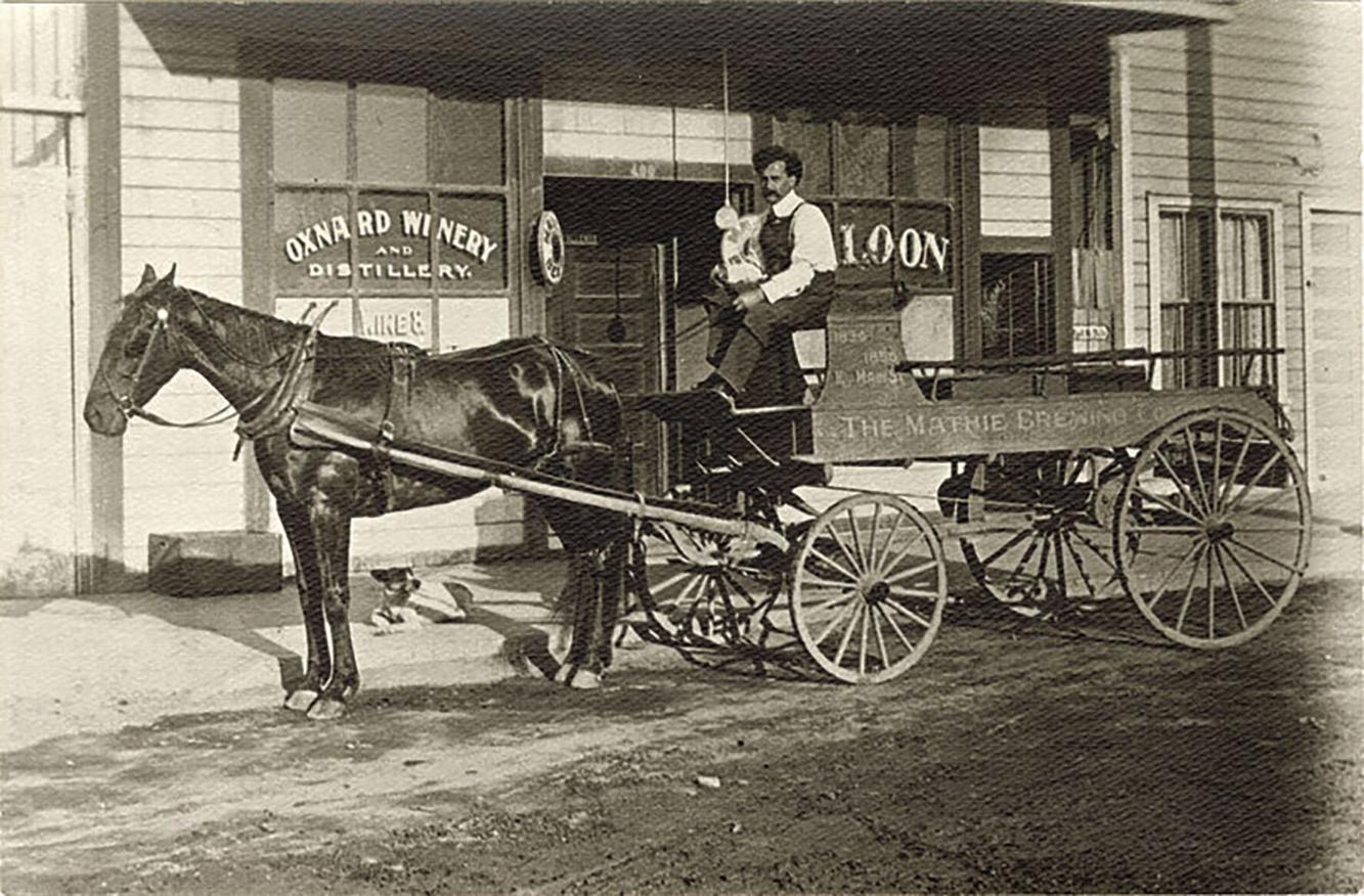 A man on a horse and carriage in the early 1900s